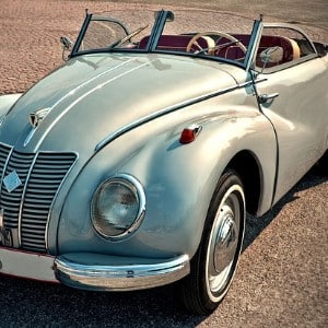 A mint green classic car in mint condition sitting on an open road