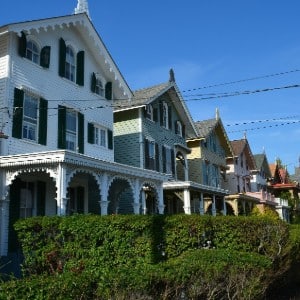 Long row of beautiful Victorian style homes with green hedges in front