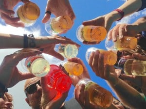 A group of friends huddled together each holding a plastic cup of beer