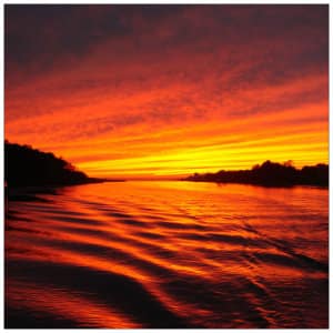 Gorgeous sunset with red and yellow sky over calm water