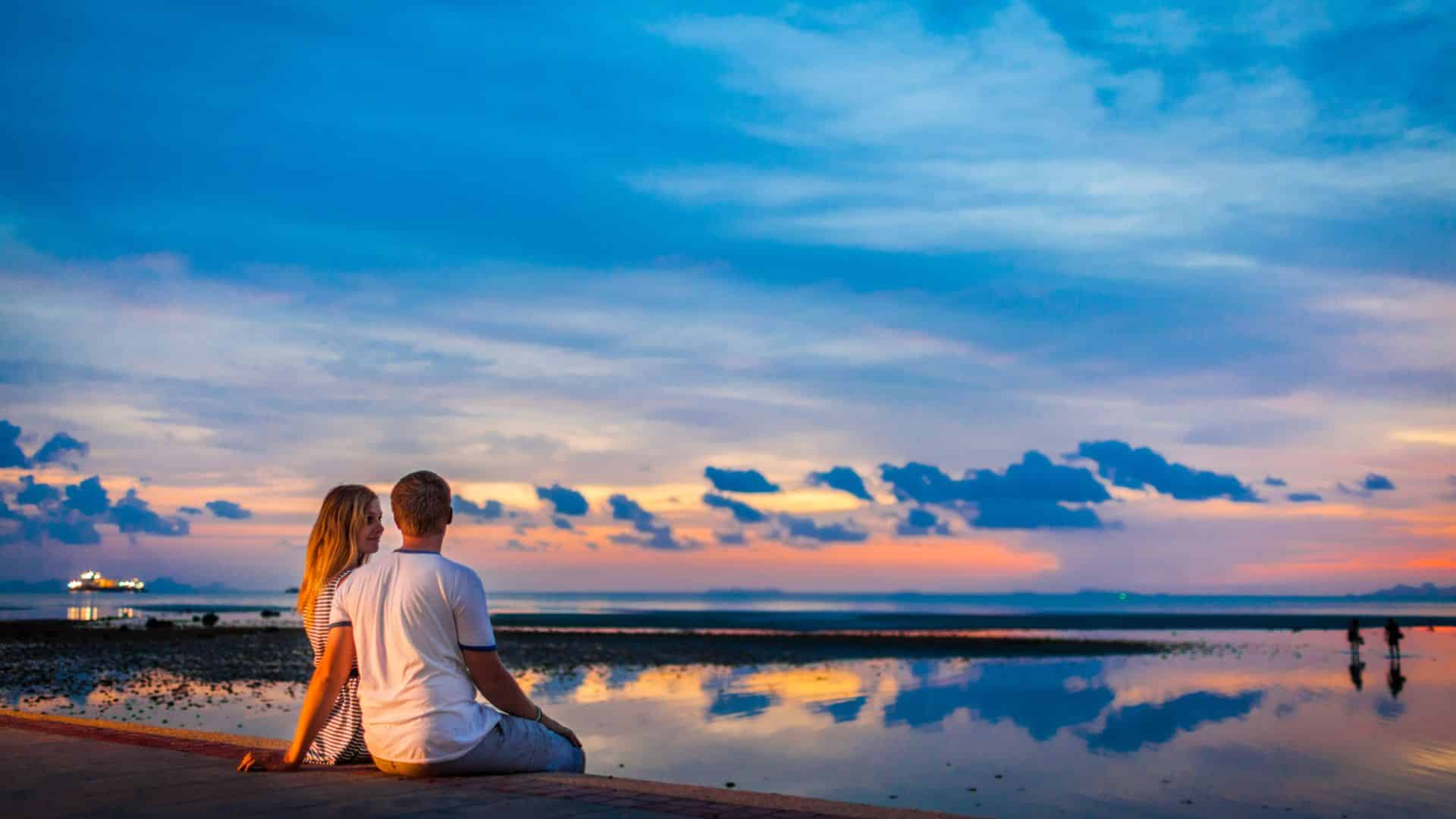 Couple together on a beach at sunset