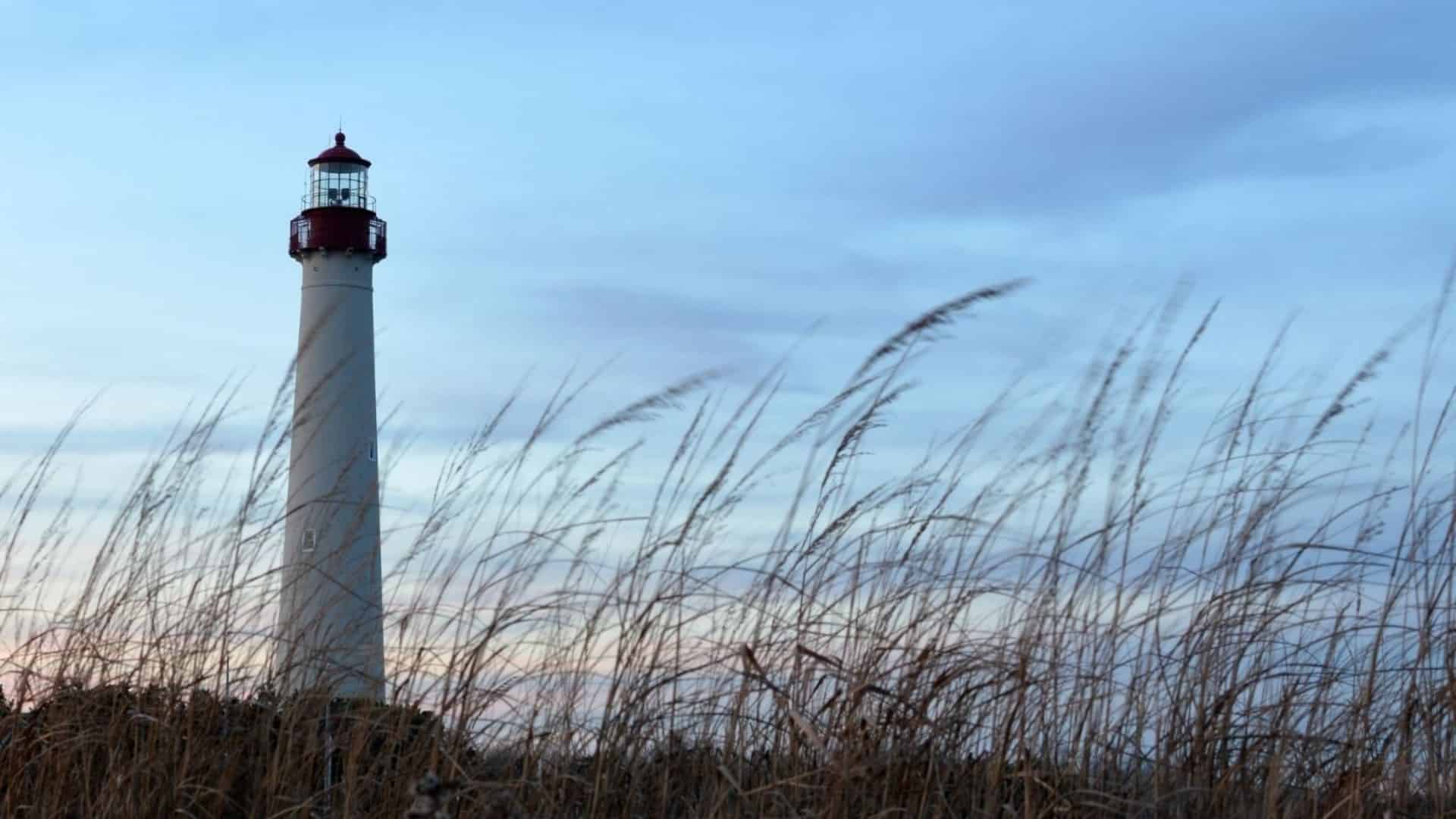 The Cape May lighthouse at sunday with seagrass blowing in the foreground