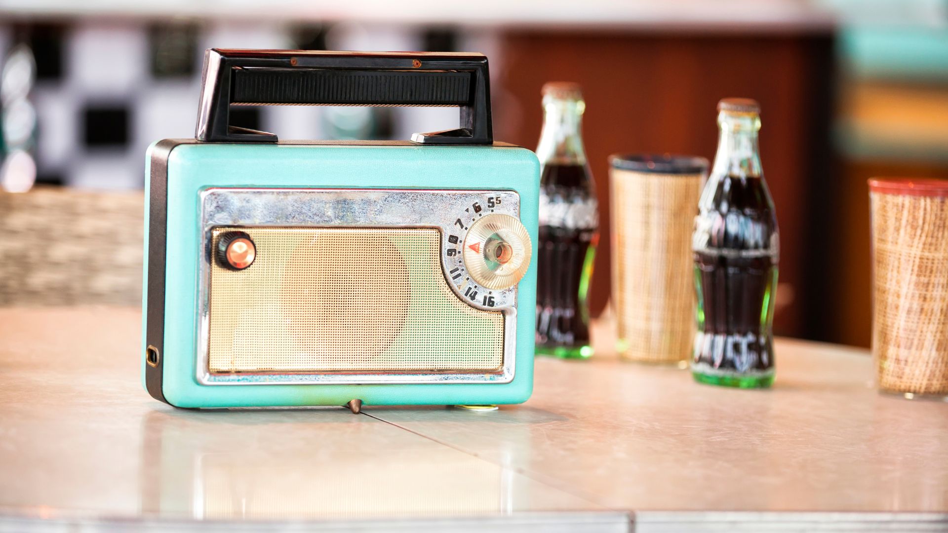1950's turquise radio, with two old fashioned bottles of coca cola sitting next to it
