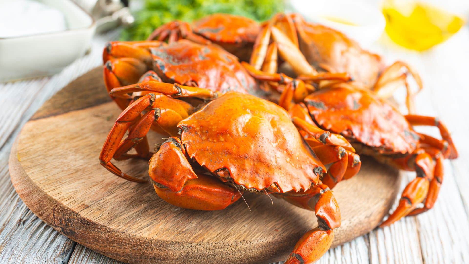 Several cooked hardshelled crabs on a wooden platter