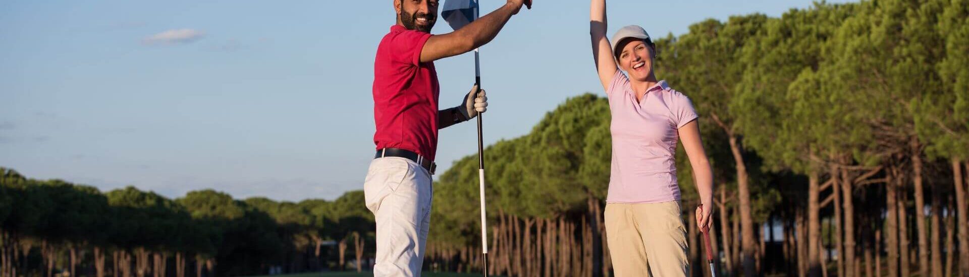 golfing couple celebrating on the green