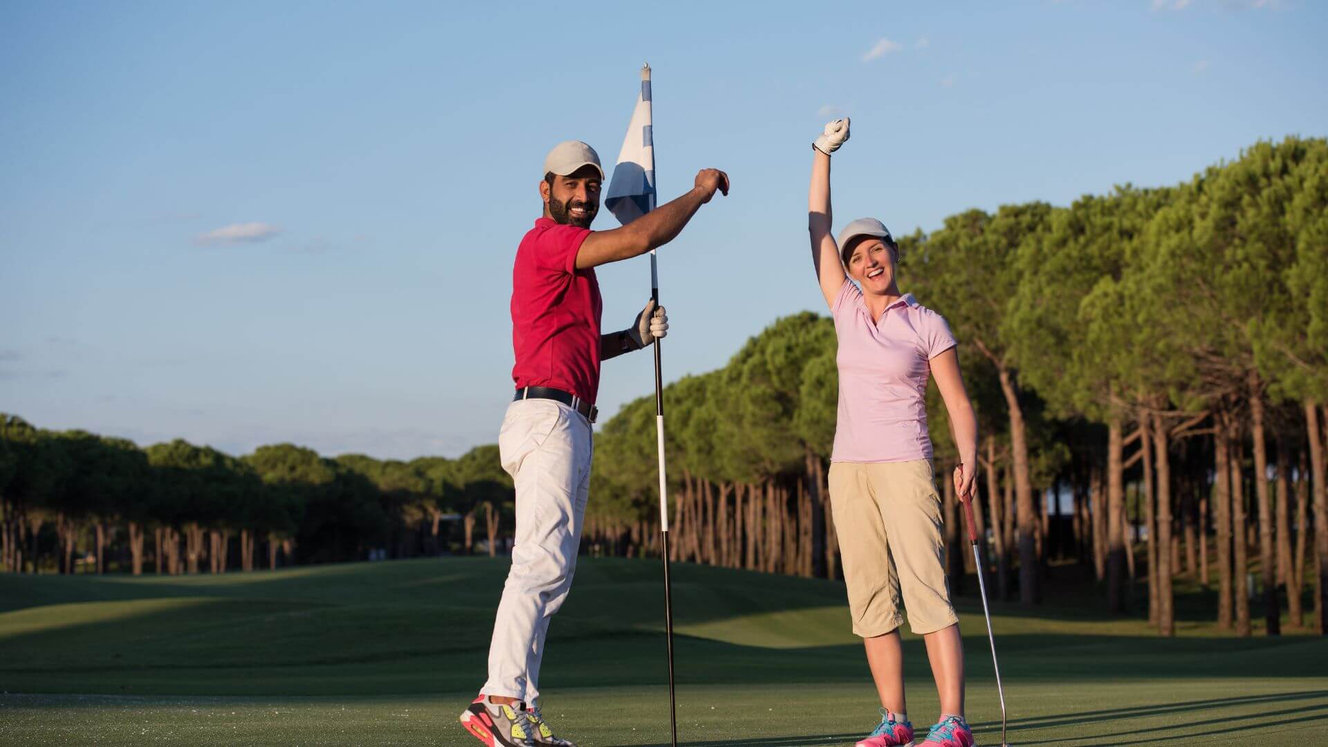 golfing couple celebrating on the green