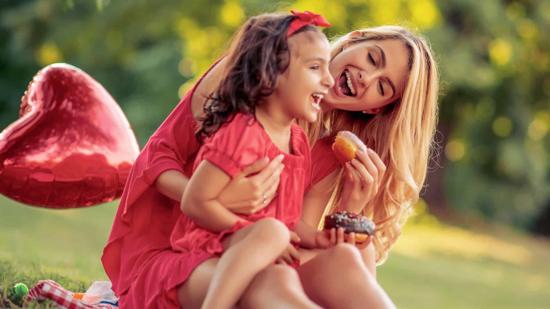 mother and daughter hugging with red heart balloons