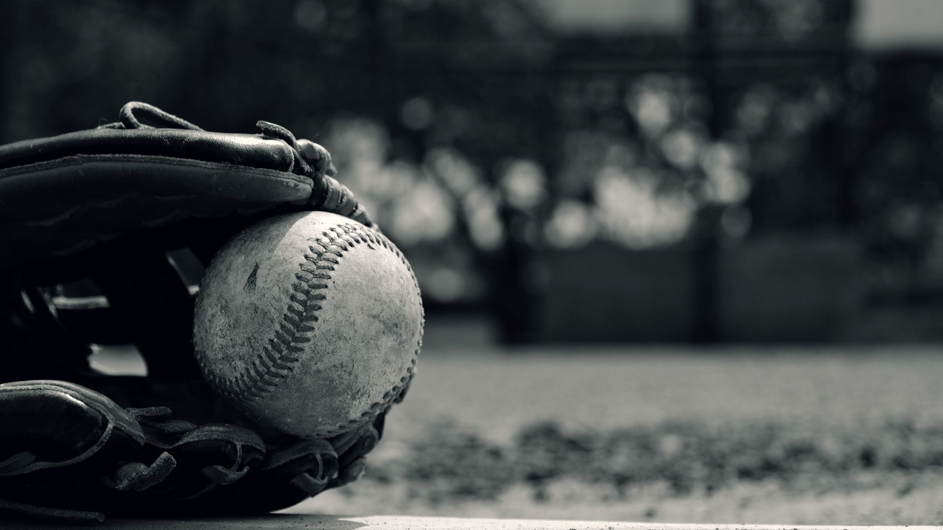 black and white photo of hand in glove with baseball