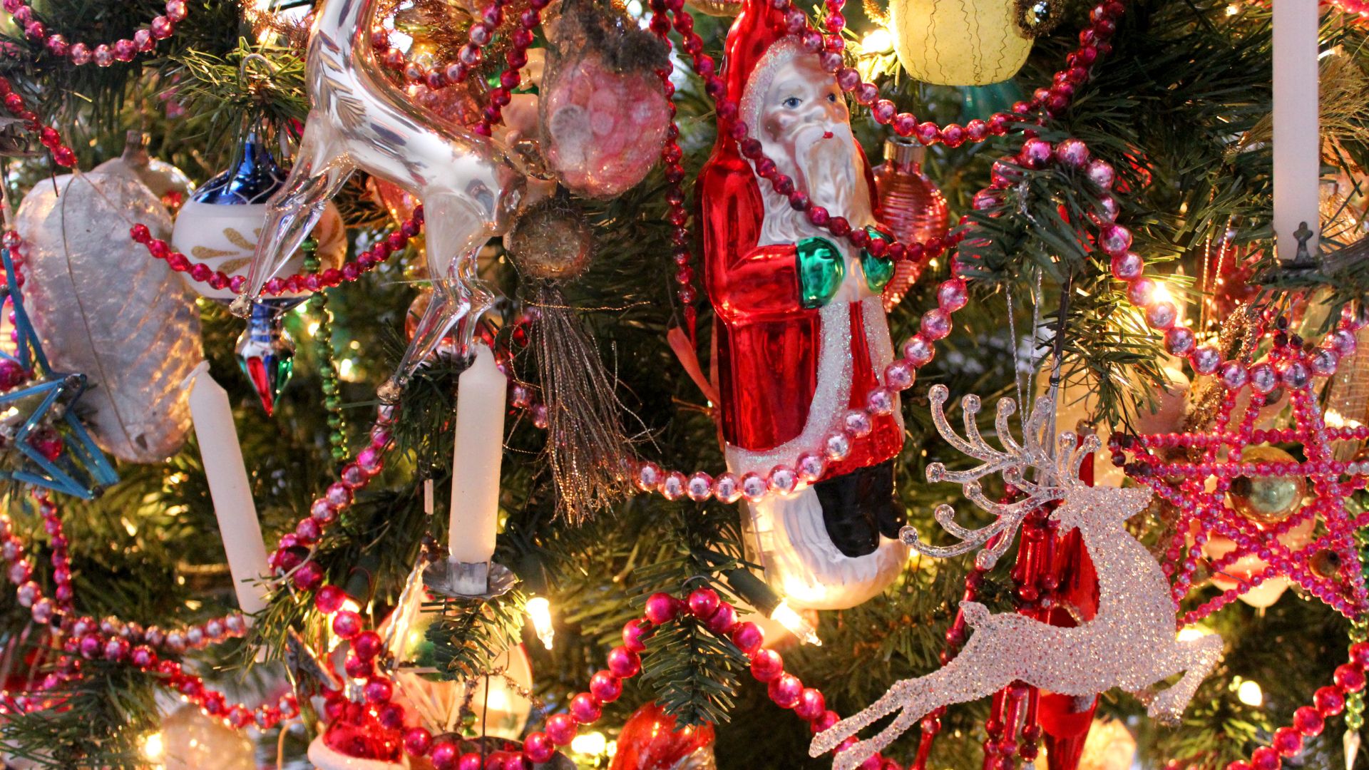 Victorian glass ornaments–santa, reindeer, pinecone with beads and candles on Christmas tree