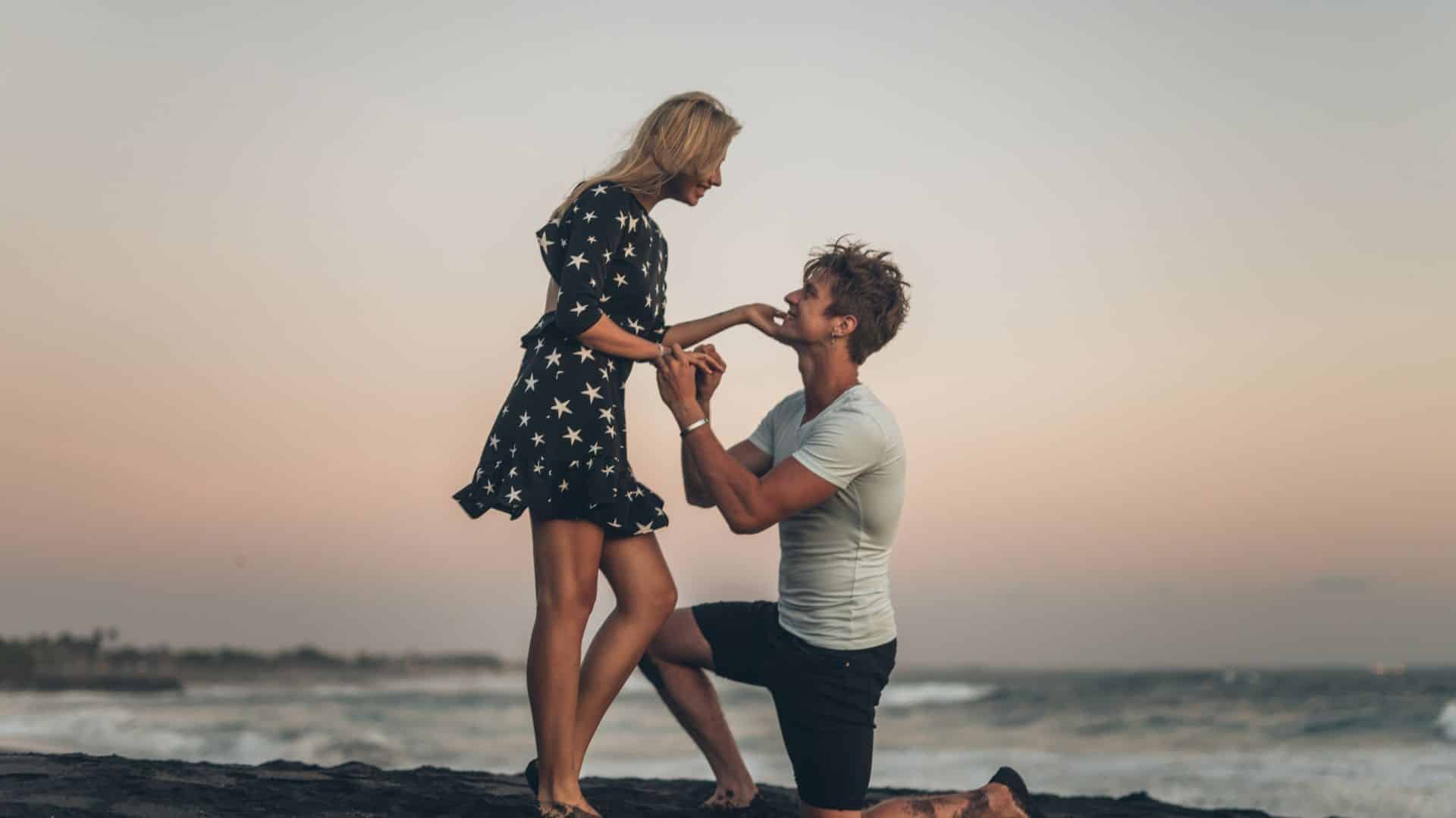 Man on beach proposing to woman