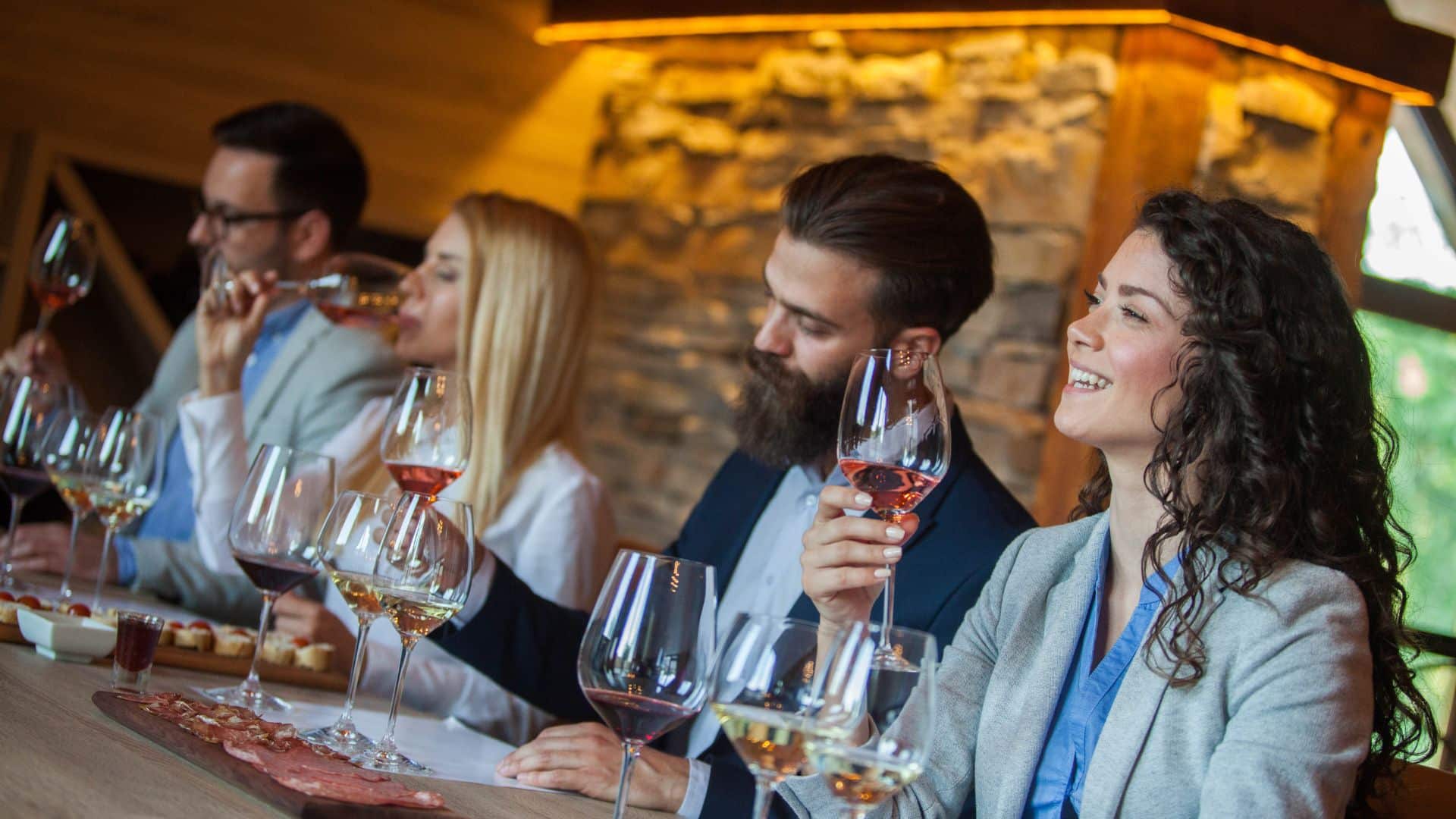 people sitting at a winery tasting bar with samples of wine in front of them