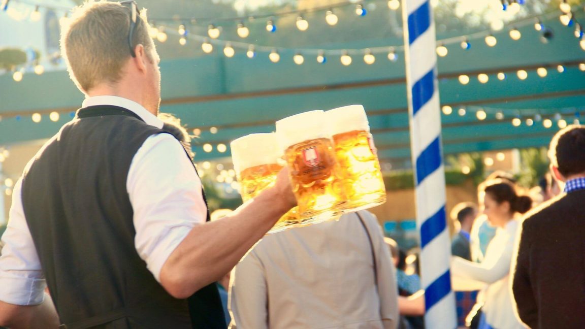 Server carrying mugs of beer at an outdoor festival