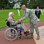 A serviceman greets a retired veteran