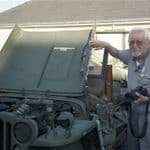 A man stands next to a Jeep