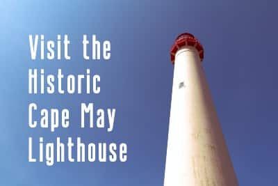 Tall white lighthouse with a red top against a clear blue sky